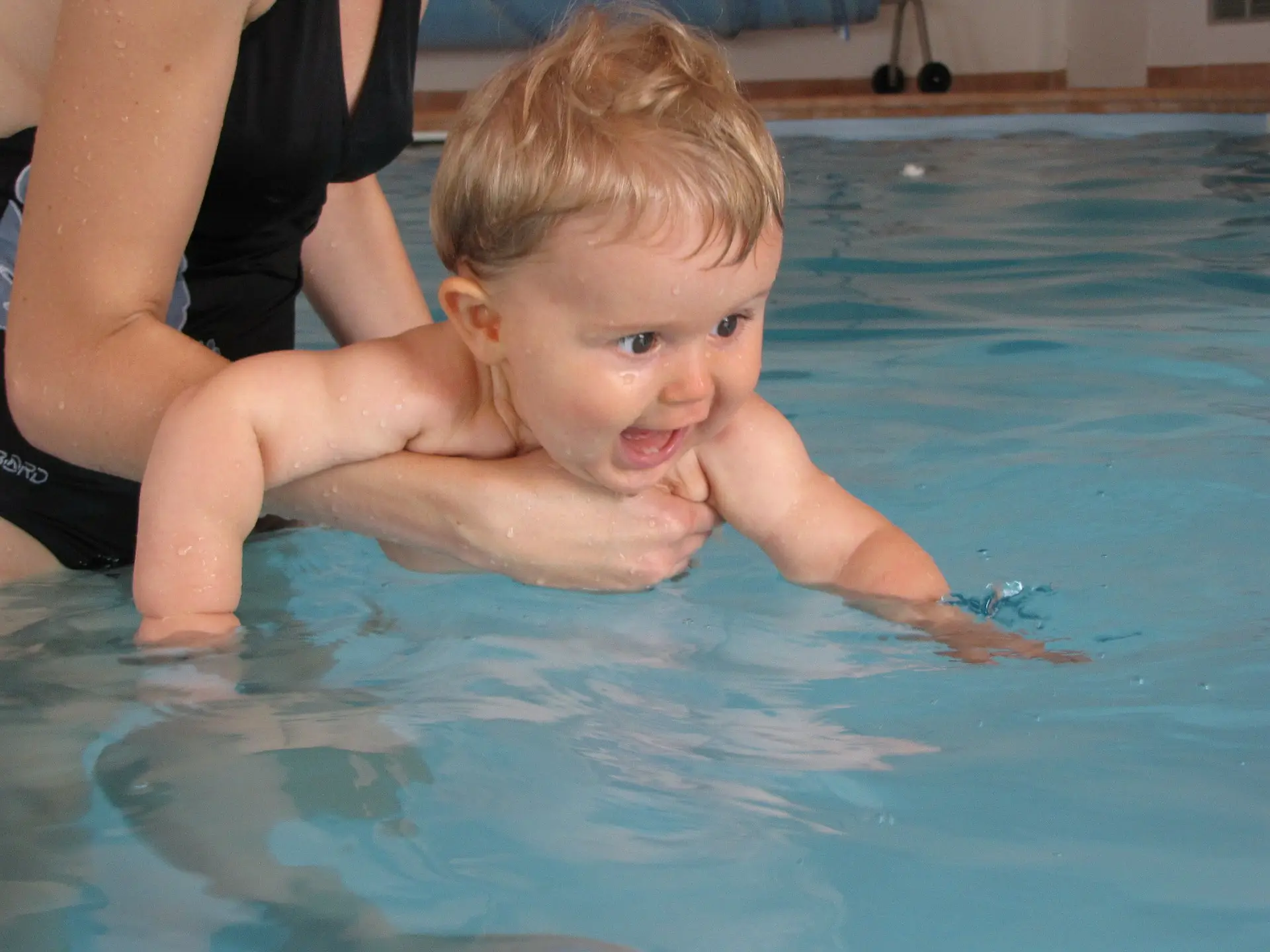 Un bébé qui apprend à nager dans une piscine avec sa maman