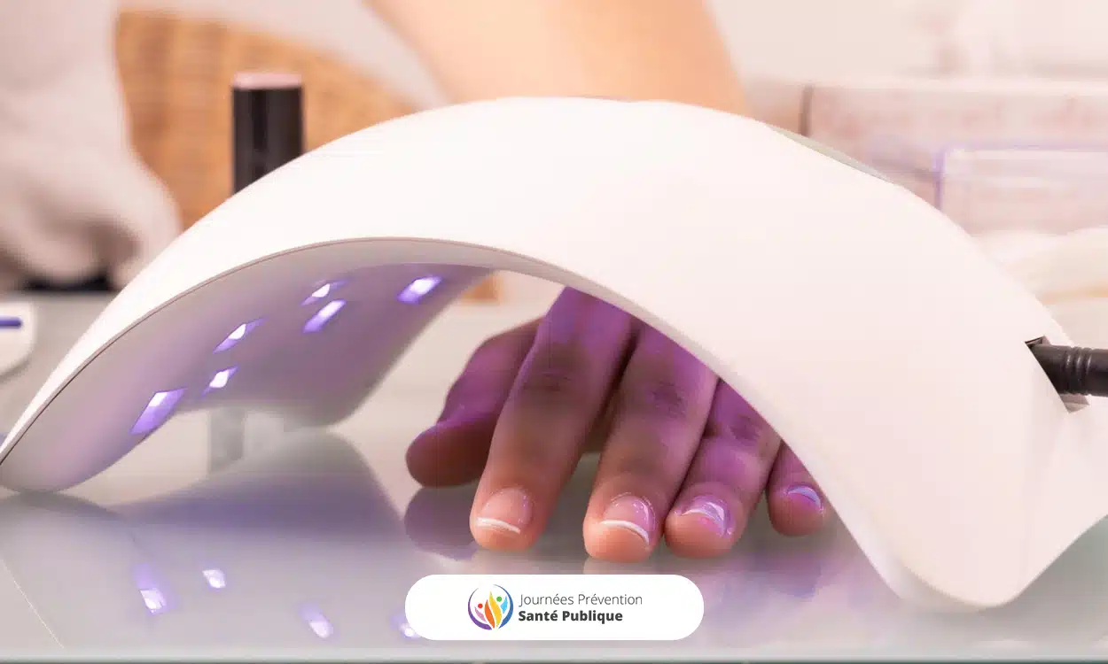 Main sous une lampe LED UV pour sécher le vernis des ongles