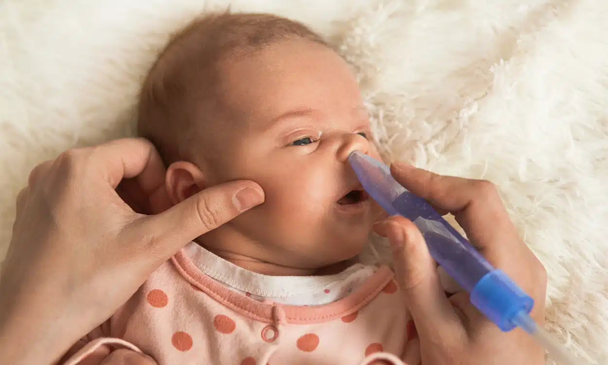 LE nettoyage de nez d'un nourrisson avec du sérum physiologique