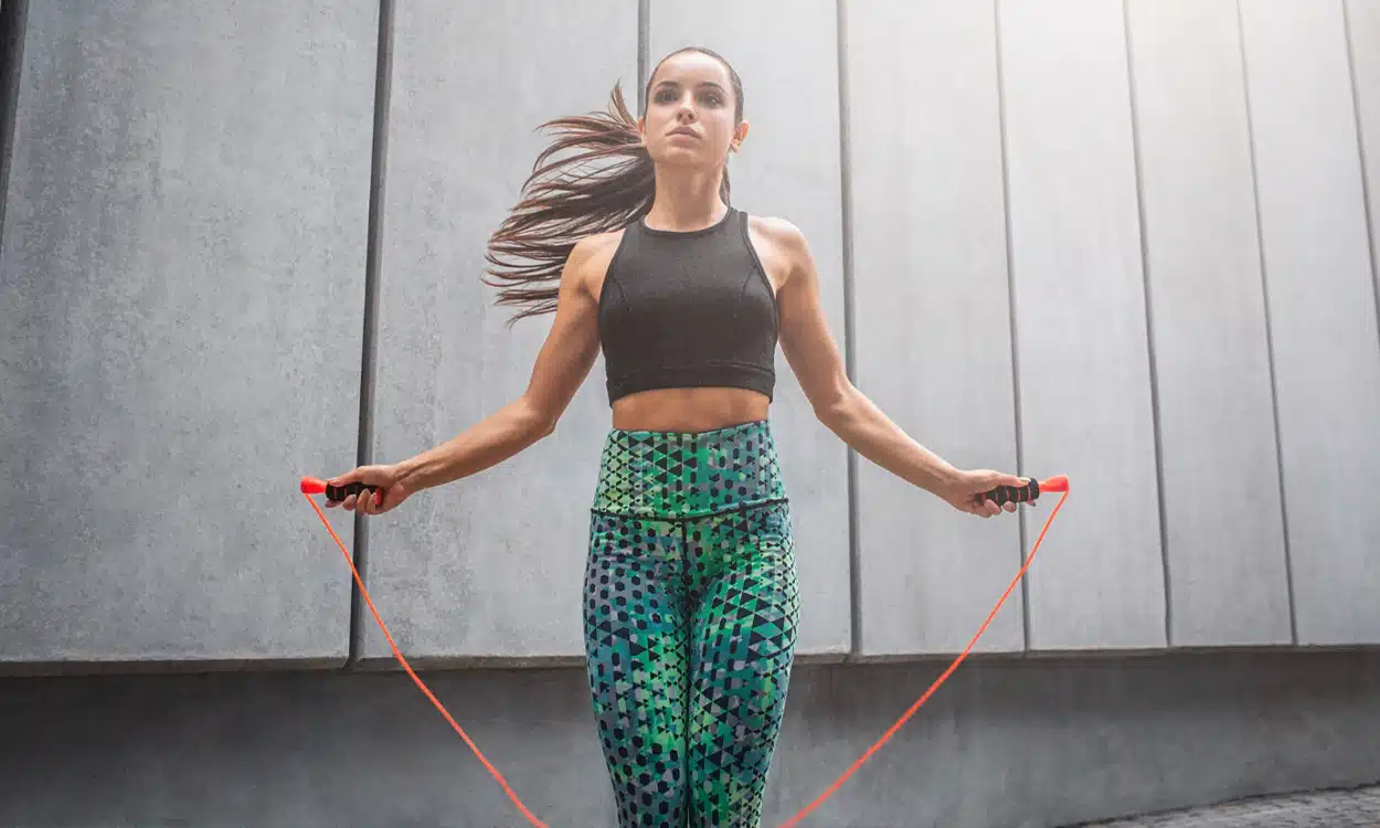 Jeune femme qui fait de la corde à sauter en tenue de sport